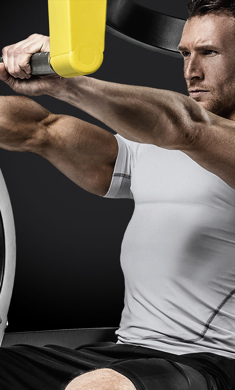 Person using the Pure Strength Chest Press Machine by Technogym in a gym